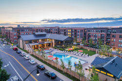 Aerial photo of yard club community center and outdoor pool with apartments in background